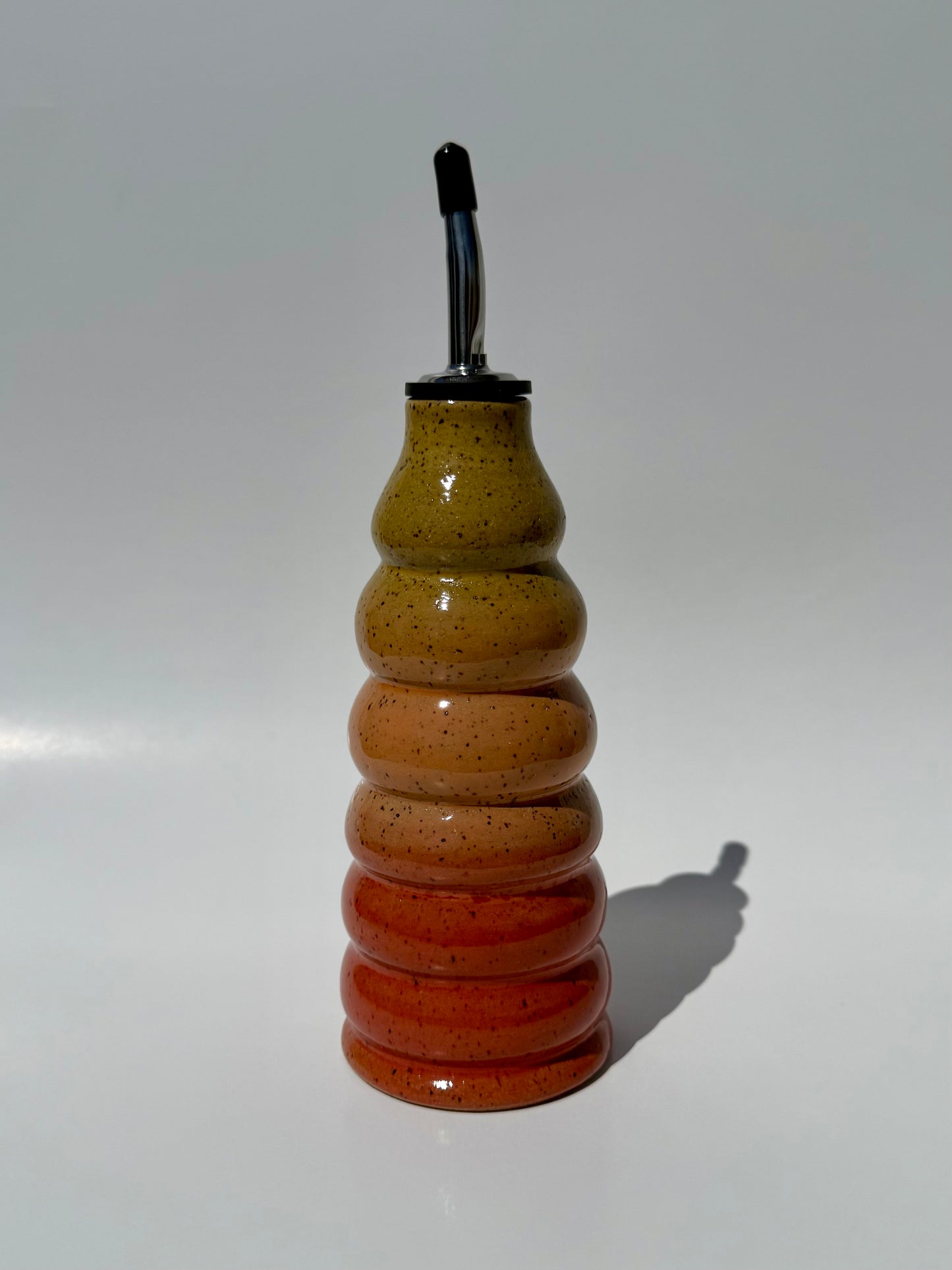 Decorative glass bottle with a striped pattern on a white background