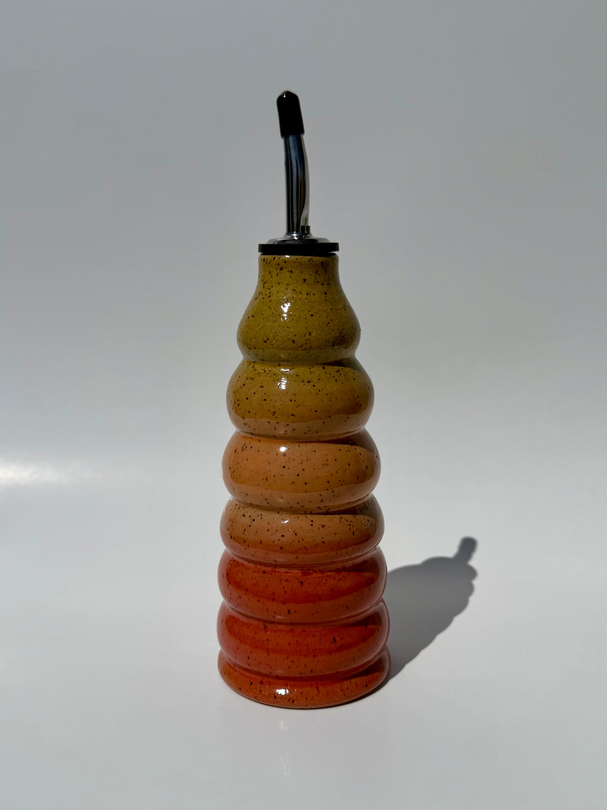 Decorative glass bottle with a striped pattern on a white background